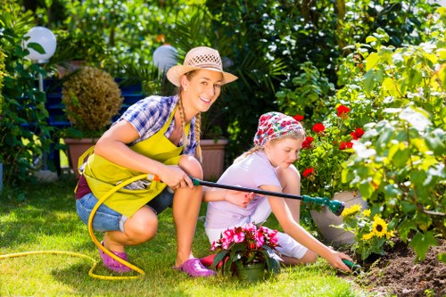 Close-up of a gardener pruning a hedge with gloves and tools